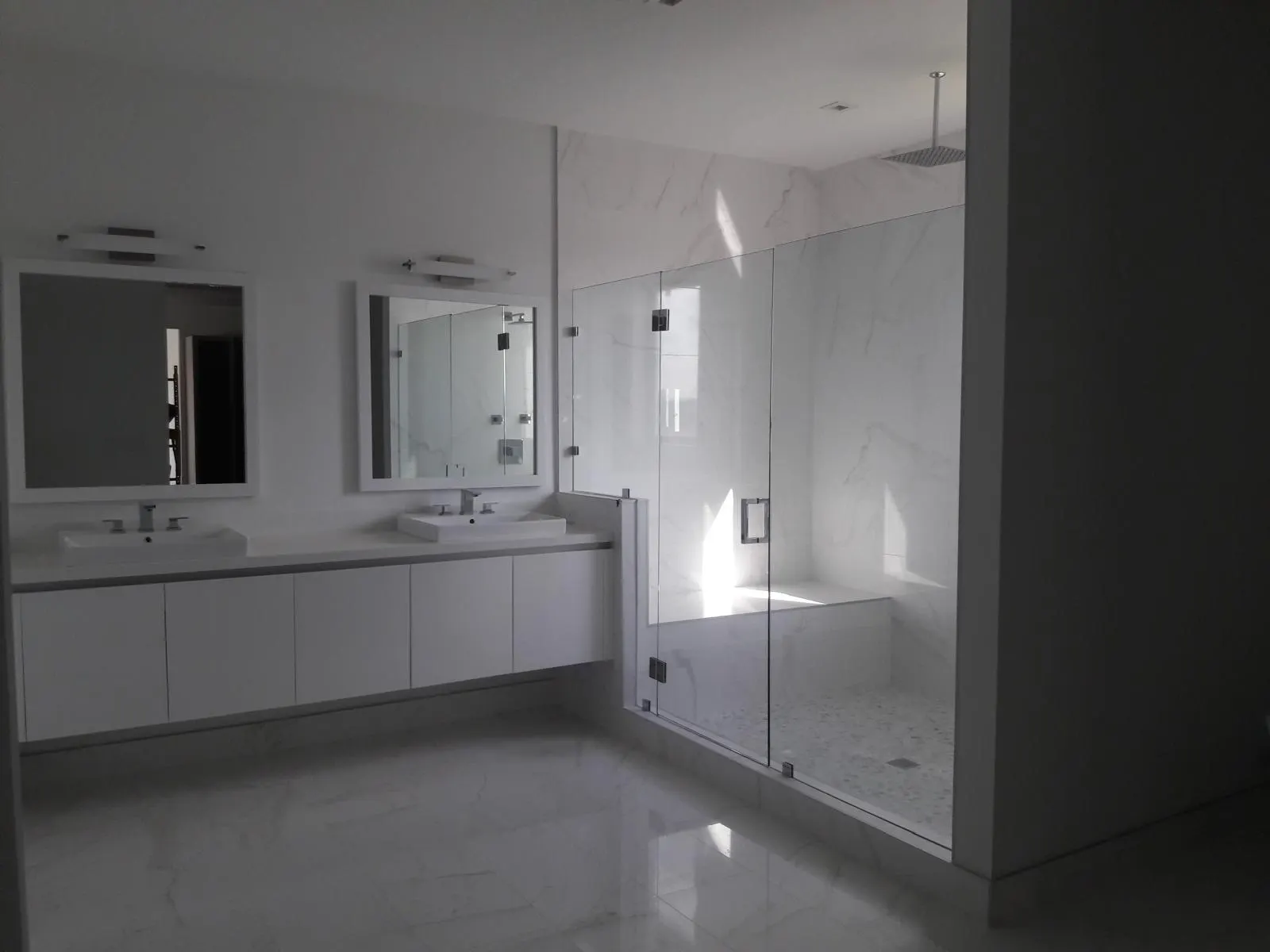 Remodeled bathroom with double vanity and glass shower in Hollywood, FL