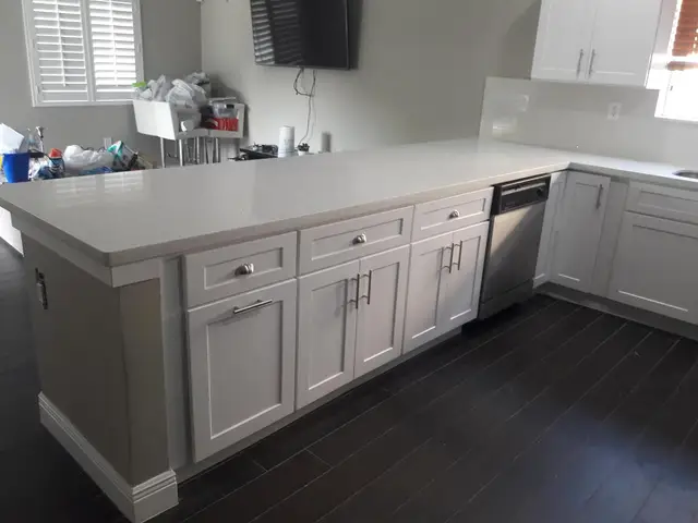 White kitchen island with dark hardwood flooring