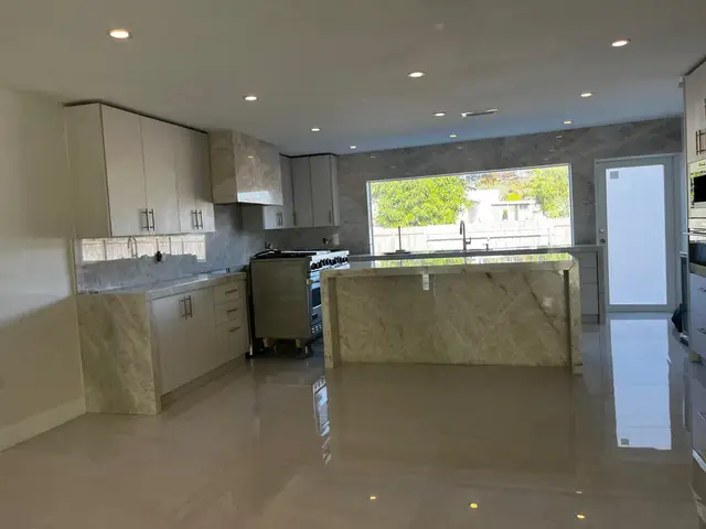 White kitchen with black tile backsplash and window
